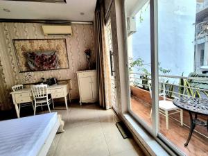 Un dormitorio con una cama y un balcón con una mesa. en F F HOUSE Homestay, en Ho Chi Minh