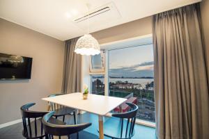 a dining room with a table and chairs and a large window at Sokcho Doo Hotel in Sokcho