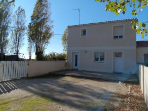 a white house with a fence in front of it at Maison paisible pour 5 pers. avec vue sur le Lay - FR-1-476-249 in LʼAiguillon-sur-Mer