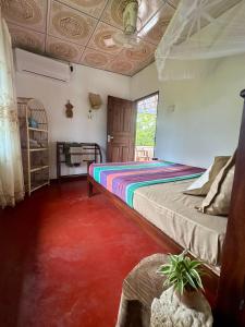 a bedroom with a bed with aicolored carpet at Stay Happy at Chathurni Villa, Ahangama in Ahangama