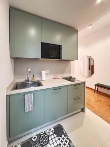 a kitchen with green cabinets and a sink at Merulana 13 in Rome +34 photos