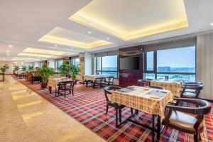 a restaurant with tables and chairs and large windows at DoubleTree By Hilton Wuxi in Wuxi