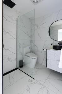 a bathroom with a toilet and a glass shower at Melrose Retreat with Court Access in Melrose +16 photos