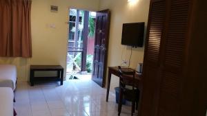 a room with a bed and a desk and a television at Eastana Cherating Beach Resort in Cherating