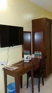 a wooden desk with a television and a telephone on it at Eastana Cherating Beach Resort in Cherating