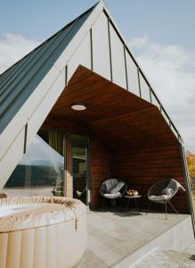 een gebouw met een dak met twee stoelen en een tafel bij Azimuth in Buhalniţa