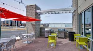 a patio with tables and chairs and a grill at Home2 Suites by Hilton Green Bay in Green Bay