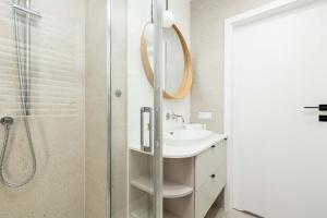 ein Badezimmer mit Waschbecken und Dusche in der Unterkunft Stylish Apartment in Kołobrzeg with Air Conditioning and Parking by Noclegi Renters in Luboszyce