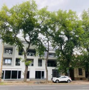 a white car parked in front of a building at Bliss & Relax Central Apartment Debrecen, Free Parking in Debrecen