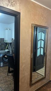a mirror on a wall next to a door at Apartament Leonardo in Roman