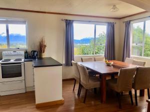 a kitchen and dining room with a table and chairs at Freestone House in Manapouri