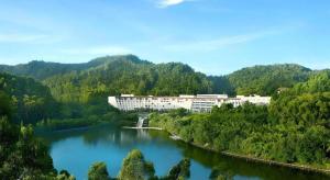 a large building in the middle of a river at Dongguan MCB Lake Hotel in Dongguan