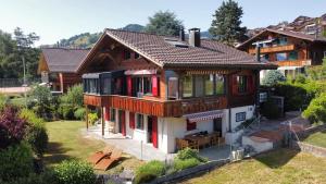 una casa con puertas rojas y techo en Chalet Zytrösli, en Sigriswil