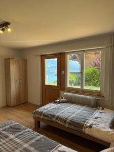 Un dormitorio con una cama grande y dos ventanas. en Chalet Zytrösli, en Sigriswil