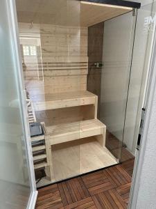 Habitación con ducha de cristal y suelo de madera. en Chalet Zytrösli, en Sigriswil 26 fotos más