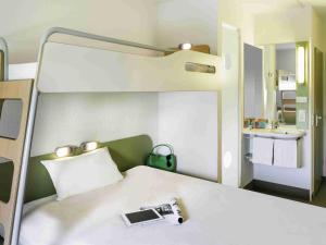 a bedroom with a bed with a camera on it at ibis budget Lyon Est Chaponnay in Chaponnay
