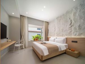 a bedroom with a large bed and a desk at Sanya Nature Reading · Fengbaijing Seaview Hotel in Yamamin
