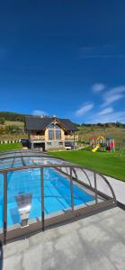 a swimming pool with a metal railing and a playground at Jaworki Prestige SPA in Jaworki
