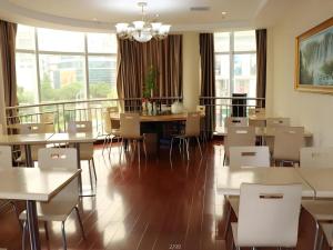 Un comedor con mesas y sillas y ventanas. en Shell Suzhou Exhibition Center Huning Chengtie Zone Station Jinfeng Square, en Suzhou