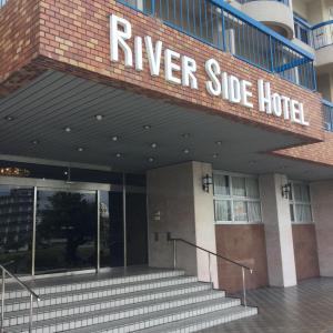 een gebouw met een bord dat staat voor een hotel aan de rivier bij Riverside Hotel Shoei in Kochi