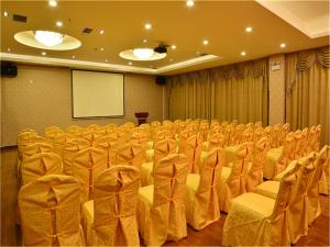 une salle de conférence avec des chaises, un podium et un écran dans l'établissement Lavande Hotel Wuhan Railway Station, à Wuhan