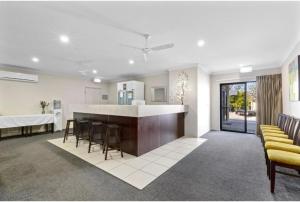 a living room with a kitchen and a bar with stools at Discovery Parks - Blackwater Central Motel in Blackwater