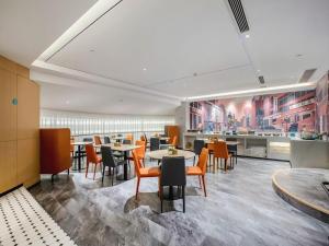 a restaurant with tables and chairs and a kitchen at City Comfort Inn Nanning Guangxi University in Nanning