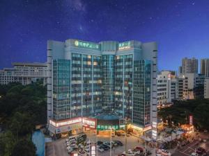 a large building with cars parked in a parking lot at City Comfort Inn Nanning Guangxi University in Nanning