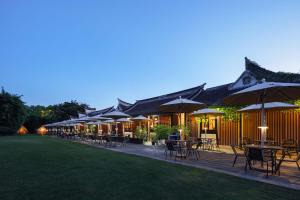 a row of tables and chairs with umbrellas at 芯宿-上海陶家宅 in Shanghai