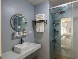 Un baño con lavabo, ducha y espejo. en 壹貳貳洋樓 l 自助入住 l 無人櫃檯, en Chiayi 66 fotos más