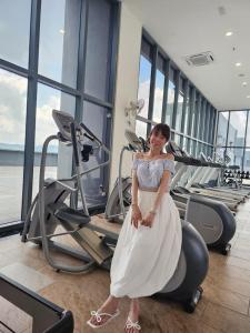 a woman in a white dress standing in a gym at 3 Tower Ampang Suite in Kuala Lumpur