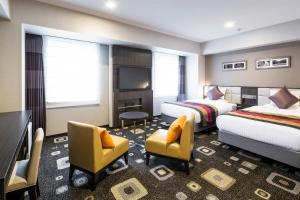a hotel room with two beds and a television at Hotel Mystays Premier Akasaka in Tokyo