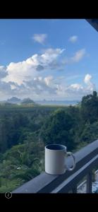 a coffee cup sitting on a balcony with a view at Villa Krabi Center in Ban Nong Chaeng