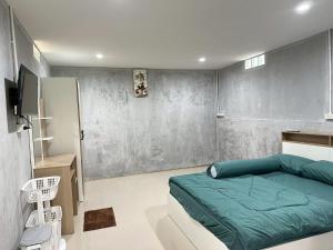 a bedroom with a green bed and a wall at Villa Krabi Center in Ban Nong Chaeng