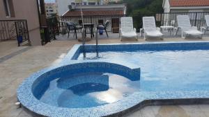 een zwembad met stoelen en een tafel en stoelen bij Apartments Lav Costas in Herceg-Novi