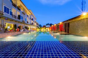 皮皮岛Phi Phi Maiyada Resort的一座空的游泳池,晚上在建筑物里