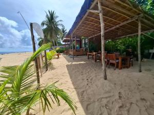 een resort met een tafel en stoelen op het strand bij Pantai Naama Bungalow  +8 foto's