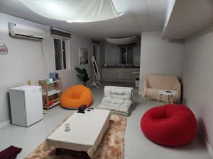 a living room with red and orange chairs and a table at 포항 파티룸 숙박깔끔 in Pohang +46 photos