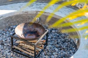 a metal pot on a stand on a pile of rocks at Stone Ridge Kintamani in Kintamani