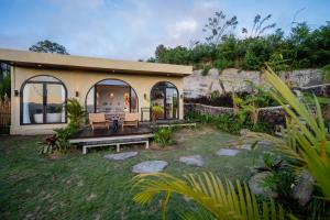 a small house with a bench in a yard at Stone Ridge Kintamani in Kintamani