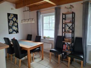 comedor con mesa de madera y sillas negras en Landgang 27, en Hemmoor