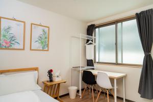 a bedroom with a bed and a desk and a window at E JOY INN-Okubo branch in Tokyo