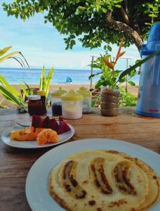 een tafel met twee borden eten op het strand bij Pantai Naama Bungalow 