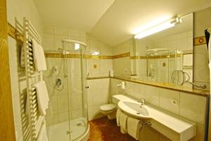 a bathroom with a sink and a toilet and a shower at Ferienwohnungen Weiherbach - Hallenbad in Berchtesgaden