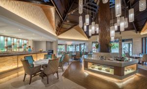 a restaurant with tables and chairs and a bar at Henann Resort Alona Beach in Panglao