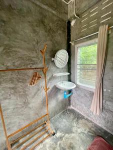 Un baño pequeño con lavabo y ventana. en Smile Resort Koh Mook, en Ko Mook