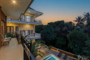 a balcony of a house with a swimming pool at Hanaka Riverside Ubud in Ubud