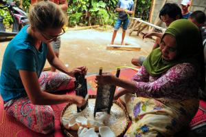 two women are sitting on the ground playing with a weapon at Green Haven Homestay in Tetebatu +143 photos