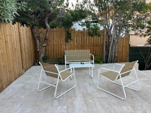 un patio con 2 sillas, una mesa y una valla en VILLA RIVA, plage et commerces à pied, en Fréjus
