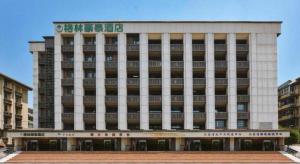 a large building with a sign on top of it at GreenTree Inn Nanjing Forestry University National Exhibition Center Express Hotel in Nanjing